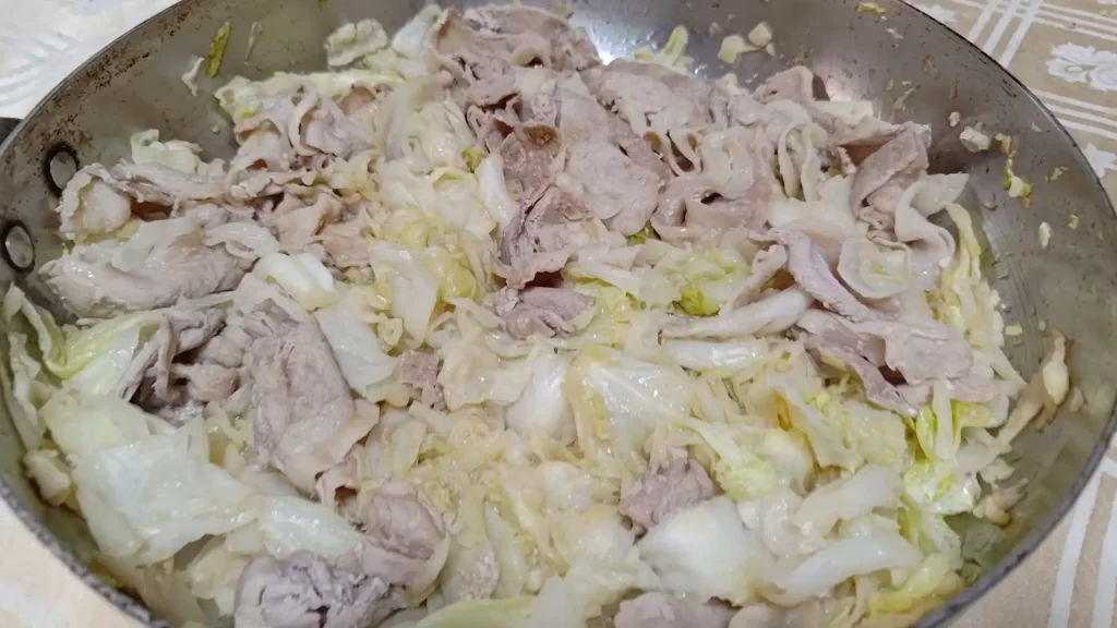 完成した春キャベツと豚肉の蒸し焼きを食卓に持ってきた様子