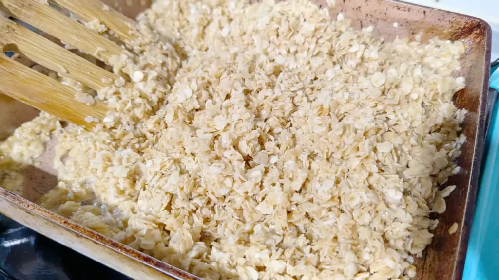 バター、砂糖、ハチミツを溶かしたものにオートミールを混ぜてフラップジャックを作っているところ